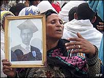A mother holds the photo of her dead son at his funeral