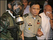 Renegade soldier Brig Gen Danilo Lim, centre, is led out of the hotel by police in Manila on 29 November 2007