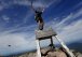FILE - Jesse Metzler, of Newton, Ma., who goes by the trail name "Sputnik," celebrates on the top of a sign marking the northern terminus of the Appalachian Trail at the summit of Mt. Katahdin, July 19, 2015, in Baxter State Park, Maine. A proposal before the Maine Legislature would ask voters to approve $30 million in public money for the design, development and maintenance of both motorized and non-motorized trails. (Derek Davis/Portland Press Herald via AP, File)
