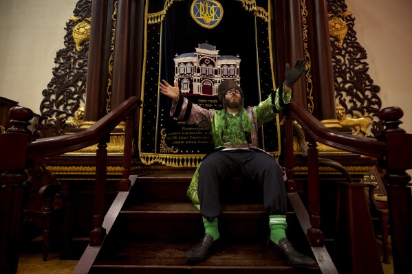 A man of the Ukrainian Jewish community gestures to the sound of music during Purim celebrations and a festive meal at the Great Choral Synagogue in Kyiv, Ukraine, Sunday, March 24, 2024. (AP Photo/Vadim Ghirda)