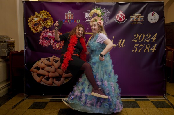 Women of the Ukrainian Jewish community playfully pose during Purim celebrations and a festive meal at the Great Choral Synagogue in Kyiv, Ukraine, Sunday, March 24, 2024. (AP Photo/Vadim Ghirda)