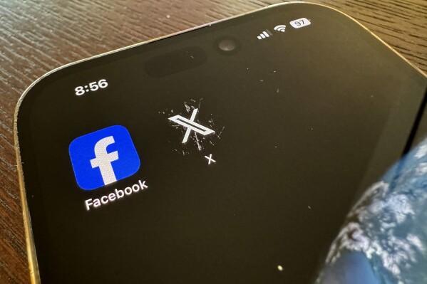 App logos for Facebook, left, and X, formerly known as Twitter, are seen on a mobile phone in Los Angeles, Saturday, March 16, 2024. (AP Photo/Paula Ulichney)
