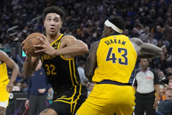 Golden State Warriors forward Trayce Jackson-Davis (32) drives to the basket against Indiana Pacers forward Pascal Siakam (43) during the first half of an NBA basketball game in San Francisco, Friday, March 22, 2024. (AP Photo/Jeff Chiu)