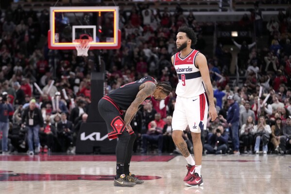 Chicago Bulls' DeMar DeRozan, left, reacts after his possible game winning 3-point shot fell short after being defended by Washington Wizards' Justin Champagnie (9) at the end of an NBA basketball game Monday, March 25, 2024, in Chicago. The Wizards won 107-105. (AP Photo/Charles Rex Arbogast)