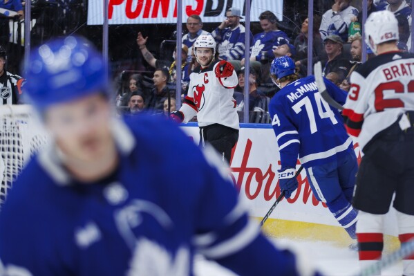 New Jersey Devils center Nico Hischier (13) celebrates after scoring a goal against the Toronto Maple Leafs during the first period of an NHL hockey game in Toronto on Tuesday, March 26, 2024. (Cole Burston/The Canadian Press via AP)