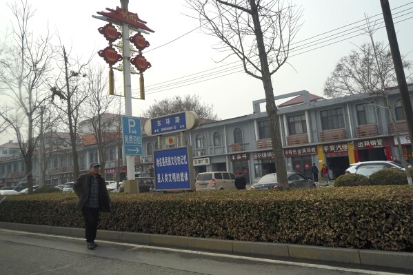FILE - A man walks along the road in the city of Handan in northern China's Hebei province on Feb. 28, 2024. Chinese authorities in the Feixiang district near Handan city announced three suspects have been detained over the March 10, 2024 gruesome murder of a thirteen-year-old boy, riveting users on Chinese social media and sparking debate over bullying and mental health in China's countryside. (AP Photo/Emily Wang Fujiyama, File)