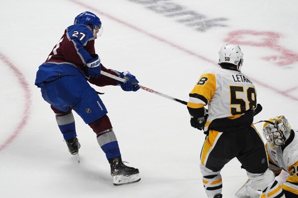 Colorado Avalanche left wing Jonathan Drouin, left, scores the winning goal past Pittsburgh Penguins defenseman Kris Letang (58) and goaltender Alex Nedeljkovic, right, in overtime of an NHL hockey game Sunday, March 24, 2024, in Denver. (AP Photo/David Zalubowski)