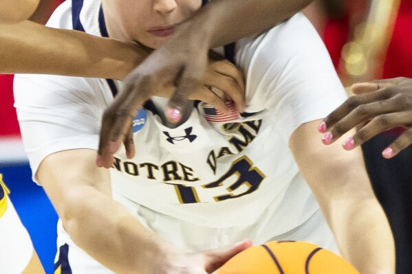 Notre Dame guard Anna DeWolfe (13) fights for a loose ball during the second half of a second-round college basketball game against Mississippi in the NCAA Tournament, Monday, March 25, 2024, in South Bend, Ind. (AP Photo/Michael Caterina)