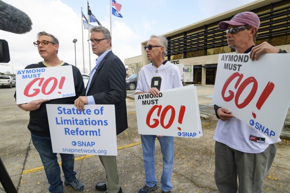 FILE - Members of SNAP, the Survivors Network of those Abused by Priests, including, from left, Kevin Bourgeois, John Gianoli, Richard Windmann and John Anderson, hold signs during a conference in front of the New Orleans Saints training facility, Jan. 29, 2020, in Metairie, La. Advocates for adult victims of childhood sexual abuse say they will ask Louisiana's Supreme Court to reconsider a ruling that wiped out 2021 legislation giving them a renewed opportunity to file civil damage lawsuits over their molestation. (AP Photo/Matthew Hinton, File)