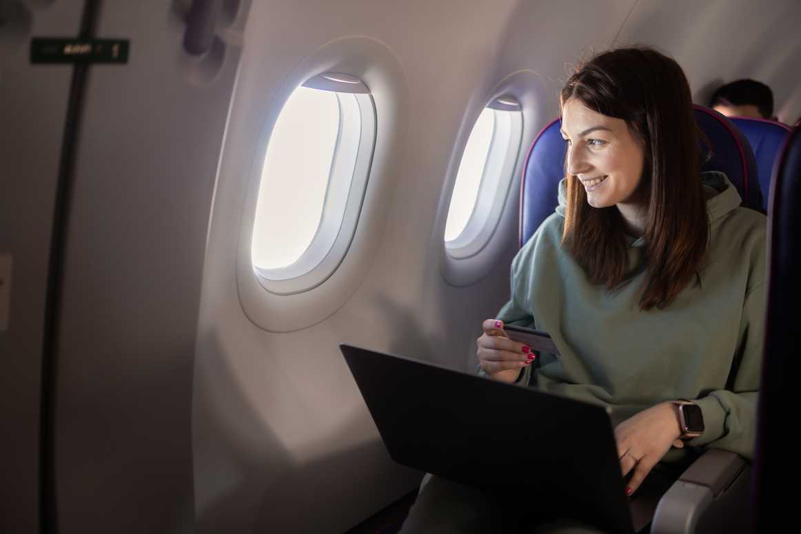women on airplane with credit card