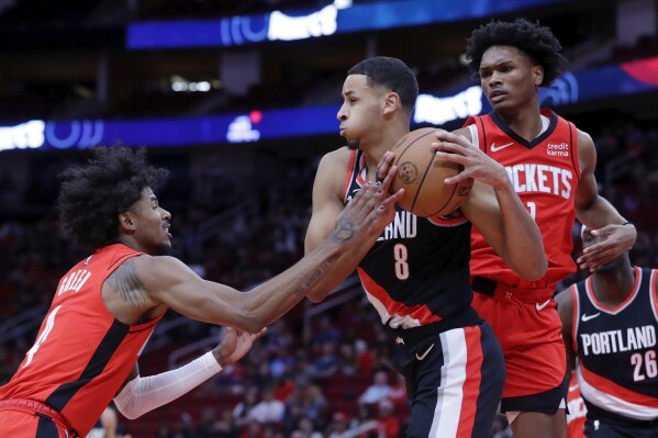 Portland Trail Blazers forward Kris Murray (8) pulls down a rebound between Houston Rockets guard Jalen Green, left, and forward Amen Thompson, right, during the first half of an NBA basketball game, Monday, March 25, 2024, in Houston. (AP Photo/Michael Wyke)