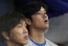 Los Angeles Dodgers designated hitter Shohei Ohtani, right, and his interpreter Ippei Mizuhara sit in the dugout during an opening day baseball game against the San Diego Padres at the Gocheok Sky Dome in Seoul, South Korea Wednesday, March 20, 2024. Ohtani’s interpreter and close friend has been fired by the Dodgers following allegations of illegal gambling and theft from the Japanese baseball star. (AP Photo/Lee Jin-man)