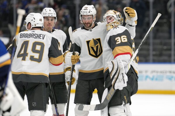 Vegas Golden Knights goaltender Logan Thompson (36) celebrates as overtime victory over the St. Louis Blues with teammates Ivan Barbashev (49), Zach Whitecloud (2) and Nicolas Roy (10) following an NHL hockey game Monday, March 25, 2024, in St. Louis. (AP Photo/Jeff Roberson)
