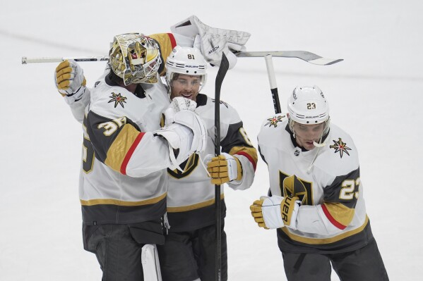 Vegas Golden Knights goaltender Logan Thompson, left; right wing Jonathan Marchessault, center; and defenseman Alec Martinez celebrate after the team's overtime win of an NHL hockey game against the Minnesota Wild, Saturday, March 30, 2024, in St. Paul, Minn. (AP Photo/Abbie Parr)