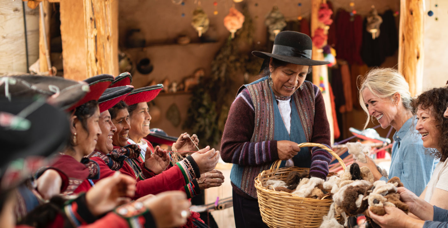 MTM experiences slider image of a lady giving happy tourists wool from a wooden basket 