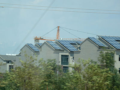 Habitats urbains en construction, les toits sont tapissés de panneaux solaires photovoltaïques, banlieue de Tourfan. Juillet 2012.