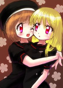 Na obrázku se nachází dvě dívky v černých uniformách, které se objímají