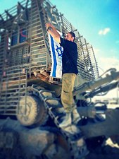 חייל צה"ל מניף את דגל ישראל על דחפור D9 משוריין