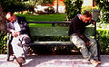 Two men sleeping on a bench.