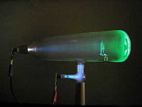 Steklena cev, ki vsebuje svetleči zeleni snop elektronov