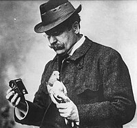 Lékárník Julius Neubronner (1914) s poštovním holubem, který má na sobě připevněn automatický fotoaparát