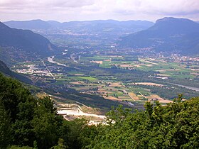 Vue de la cluse de Voreppe depuis les hauteurs de Sassenage au sud avec le massif de la Chartreuse à droite et Voreppe à ses pieds, le massif du Vercors à gauche et les reliefs des Terres froides en arrière-plan.