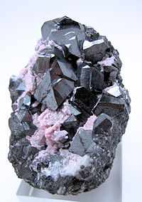 Grupp av oktaedriska alabandinkristaller, delvis belagda med rosa rodokrosit, från Uchucchacuagruvan, Oyon, Lima, Peru (storlek: 60 mm x 59 mm x 46 mm, 204 g.)