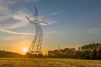 Zauberlehrling (aprendiz de feiticeiro) é uma escultura em aço parecendo uma torre de energia em movimento de dança, fotografada ao pôr do sol. Criada para a EMSCHERKUNST, uma exposição internacional de arte em espaço público realizada no norte da Região do Vale do Ruhr, Alemanha. (definição 3 836 × 2 557)