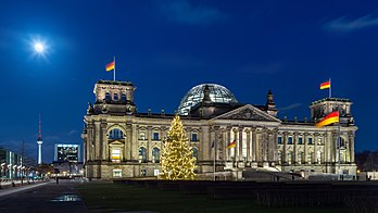 Vista noturna do Palácio do Reichstag em Berlim, Alemanha. Em primeiro plano uma árvore de Natal, à esquerda o edifício do Centro de Comércio Internacional (Friedrichstraße) e ao fundo a torre de televisão (Alexanderplatz). (definição 6 000 × 3 375)