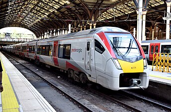 A long, sleek, white Greater Anglia/Stansted Express train at a platform at London Liverpool Street station.