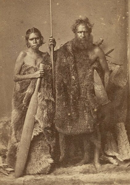 File:Aboriginal couple wearing kangaroo cloaks. The man is posed with a shield and a spear, while the woman is holding a sword club (ca. 1880).jpg