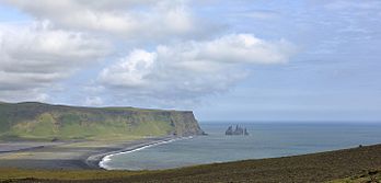 Praia de Reynisfjara e as rocas de basalto de Reynisdrangar vistas da península de Dyrhólaey, Islândia. (definição 5 640 × 2 703)