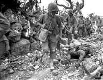 Amerikai katonák vágnak át egy elpusztított okinavai falun 1945-ben