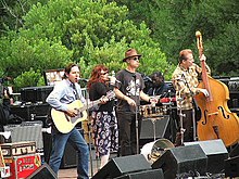 The band onstage at an outdoor concert in 2005