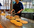 A man prepares okonomiyaki