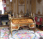 Bureau du Roi (Rococo); by Jean-François Oeben and Jean Henri Riesener; 1760–1769; bronze, marquetry of a variety of fine woods and Sèvres porcelain; 147.3 x 192.5 x 105; Palace of Versailles (Versailles, France)[61]