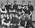 An inot na Basketbol team kan University of Kansas, 1899. Si coach James Naismith an nakatindog sa pinakahurihang tuo
