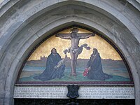 The tympanum of the Thesis Door at the Castle Church in Wittenberg depicts Martin Luther and Philip Melanchthon kneeling in prayer, facing the crucified Christ.