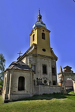 Barokní kostel sv. Jana Křtitele. Snímek z května 2016 zachycuje novou střechu a částečně opravenou fasádu věže