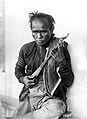 Seorang kakek memainkan kulcapi, yaitu alat musik tradisional Karo.