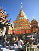 仏塔を前にし、線香、御花、蝋燭などを捧げる仏教徒たち（タイ王国、ワット・プラタートドーイステープ）