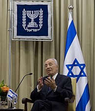 Die President van die Staat Israel, Shimon Peres, met die Israeliese vlag en die Wapen van die President