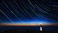 Circumpolar stars in star trails at the La Hague lighthouse, France.