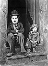 Charlie Chaplin (1889–1977) som sin odödliga komedikaraktär "The Tramp", här mot Jackie Coogan (1914–1984) i klassikern "Chaplins pojke" ("The Kid", 1921).