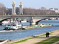 Quatre petites barges de sable passant sous le pont Alexandre-III.