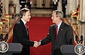 Tony Blair and George W. Bush shaking hands at a press conference.