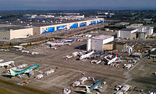 Pabrik Boeing di Everett, Washington pada tahun 2011. Pesawat-pesawat berada di tarmak di luar bangunan menyerupai gudang