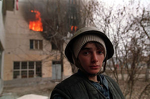 Čečenu zēns pie degošas mājas Pirmās Groznijas kaujas laikā