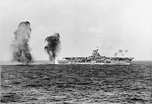 Британський авіаносець «Арк Роял» під час битви біля мису Спартівенто під бомбардуванням італійської авіації. Фото з борту легкого крейсера «Шеффілд». 27 листопада 1940 року
