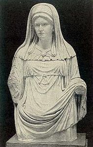 تمثال فستال العذراء مرتدية بالا ووشاحاً ذا لون أبيض.